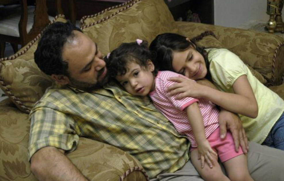 A family cuddles on a sofa